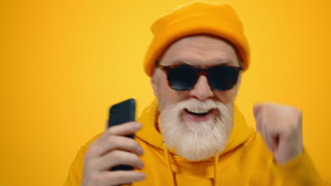 戴墨镜的时髦白胡子老年男性在听音乐摇摆14秒视频