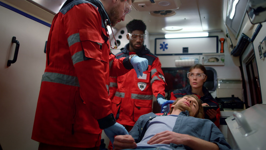 护理人员检查紧急救护车内担架上男子脉搏视频