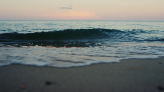 蓝色的海浪在夏天的早晨以慢动作打破沙滩海滨视频