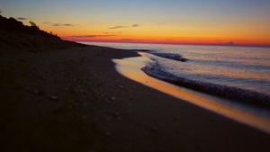 在金色的日出时全景欣赏宁静的海滨和山的轮廓16秒视频