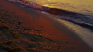 特写镜头湖波浪飞溅在早晨日出黎明的沙子海岸岸边10秒视频