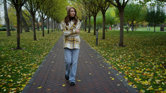 美丽的时髦女孩在秋天公园散步视频