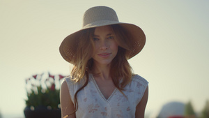 性感的金发女人戴着遮阳帽在外面明亮的夏日看着相机7秒视频