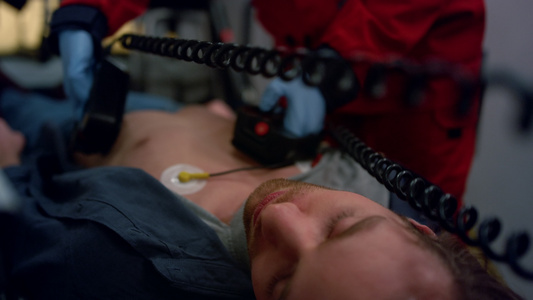 医生用外部除颤器救病人 辅助医疗员进行救治视频