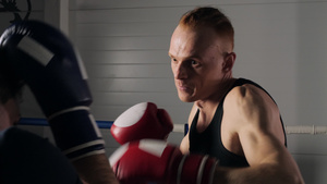 拳击手戴着手套与拳击训练的陪练伙伴打架9秒视频