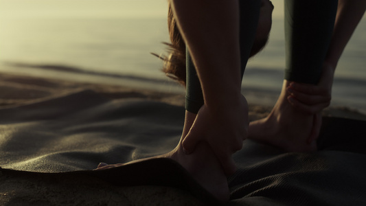 灵活的女运动员在海滩特写镜头上弯曲身体到脚视频