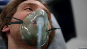 身戴氧气面具的受伤男子躺在救护车上的担架12秒视频