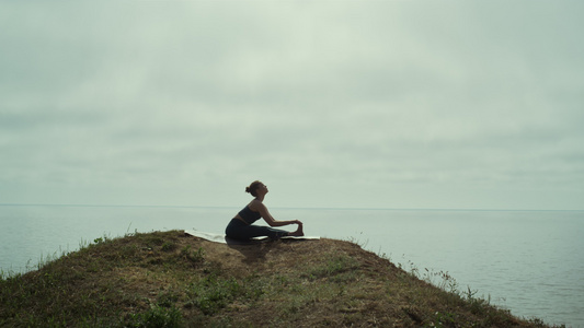 坐在青山海边的女人锻炼瑜伽视频