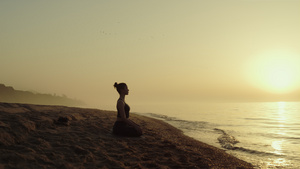 瑜伽女人在沙滩上练习冥想27秒视频