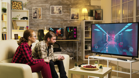 男朋友在玩电子游戏时用TV屏幕指着女友的女朋友视频