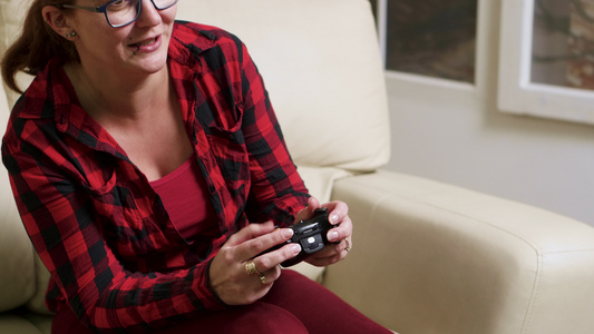 坐在沙发上玩电子游戏的单身单身妇女视频