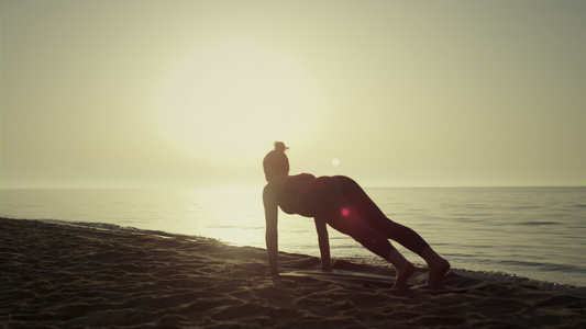剪影瑜伽女人在海滩上锻炼视频