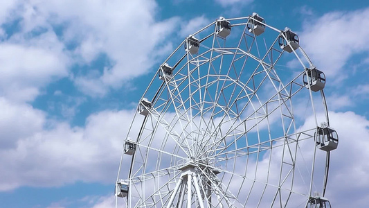 在一个游乐园里快速旋转着发风车轮在云端的天空中视频