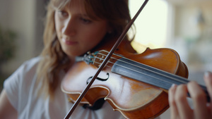 在家拉小提琴的女孩 在乐器上弹奏和弦的小提琴家16秒视频