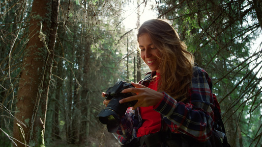 女孩带着照相机站在森林里视频