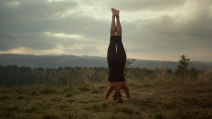 运动健壮的女员在做头立瑜伽姿势15秒视频