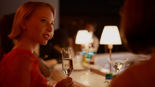 在酒吧喝香槟的漂亮女孩在酒吧跟朋友说话视频