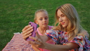 母亲和女儿在公园里摆姿势 家人在户外的手机上自拍22秒视频