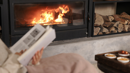 冬季火炉边看书取暖的女性视频