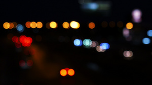 城市背景模糊夜间交通在街上行驶的汽车灯光下移动16秒视频