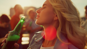 年轻女子在日落屋顶喝啤酒21秒视频
