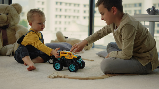 可爱的兄弟俩在家里地毯上快乐的玩玩具赛车视频
