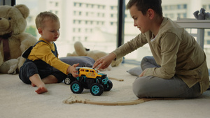 可爱的兄弟俩在家里地毯上快乐的玩玩具赛车15秒视频