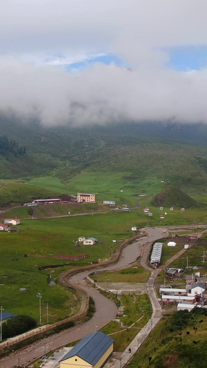 云雾缭绕的雪山脚下散落的村庄航拍视频自然风光51秒视频