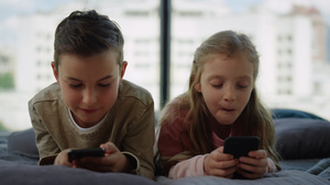 哥和姐在手机上玩游戏 小兄弟在家里用智能手机玩17秒视频