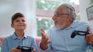 老年人和孙子在家里玩游戏机25秒视频