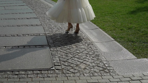 穿着结婚礼服的年轻新娘在城市中行走白色豪华礼服时装6秒视频
