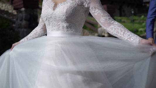 穿着婚纱的年轻新娘在公园里盘旋白色豪华礼服时装视频