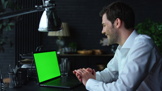商人视频在办公室绿色屏幕上用笔记本电脑在线聊天视频