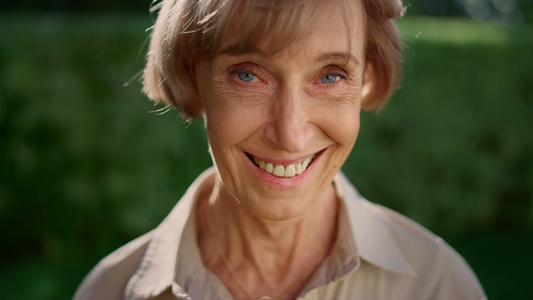 在绿色公园微笑的老太太老奶奶老年人女性面部特写视频