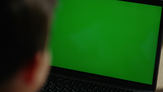 男孩使用绿色屏幕电脑视频