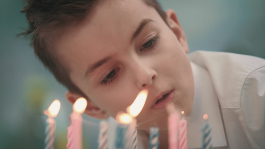 男孩在蛋糕上吹蜡烛火焰视频