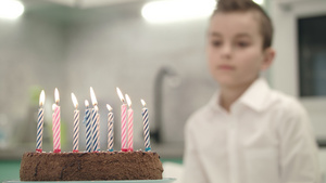 男孩在看生日蛋糕 与蜡烛上火焰7秒视频