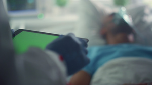 医生拿着平板电脑绿屏屏幕检查病人病史特写22秒视频