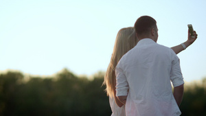 日落时拍照的浪漫情侣背影16秒视频