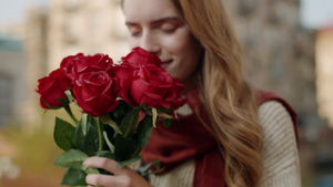 美女在户外街头约会手捧玫瑰花闻花香表情幸福12秒视频