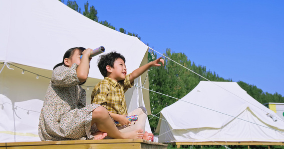 两个孩子坐在帐篷外玩耍视频