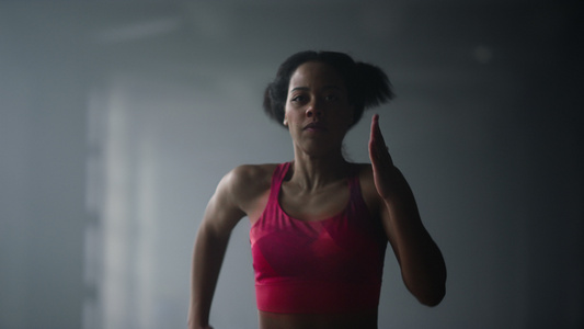 在健身房黑暗走廊里快速奔跑的女性运动员视频