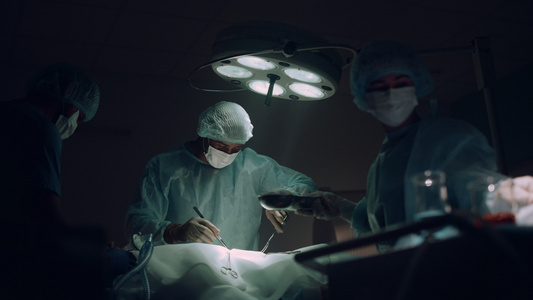医生团队在黑暗的医院手术室进行外科手术视频