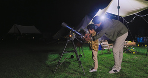 傍晚爸爸和儿子在露营地用望远镜看星空18秒视频