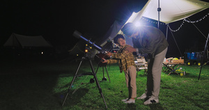 傍晚爸爸和儿子在露营地用望远镜看星空7秒视频