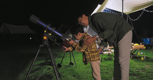 傍晚爸爸和儿子在露营地用望远镜看星空14秒视频