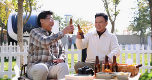 两个老年男人坐在房车露营院子里聊天喝啤酒15秒视频