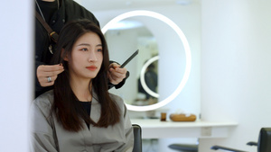 女顾客通过镜子看发型师给自己做造型31秒视频