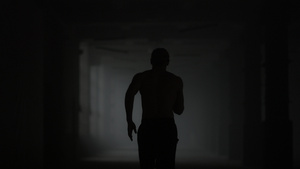 在黑暗的走廊的健身男性慢跑训练30秒视频