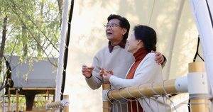 中老年夫妻搂着肩膀靠着栏杆喝茶聊天15秒视频